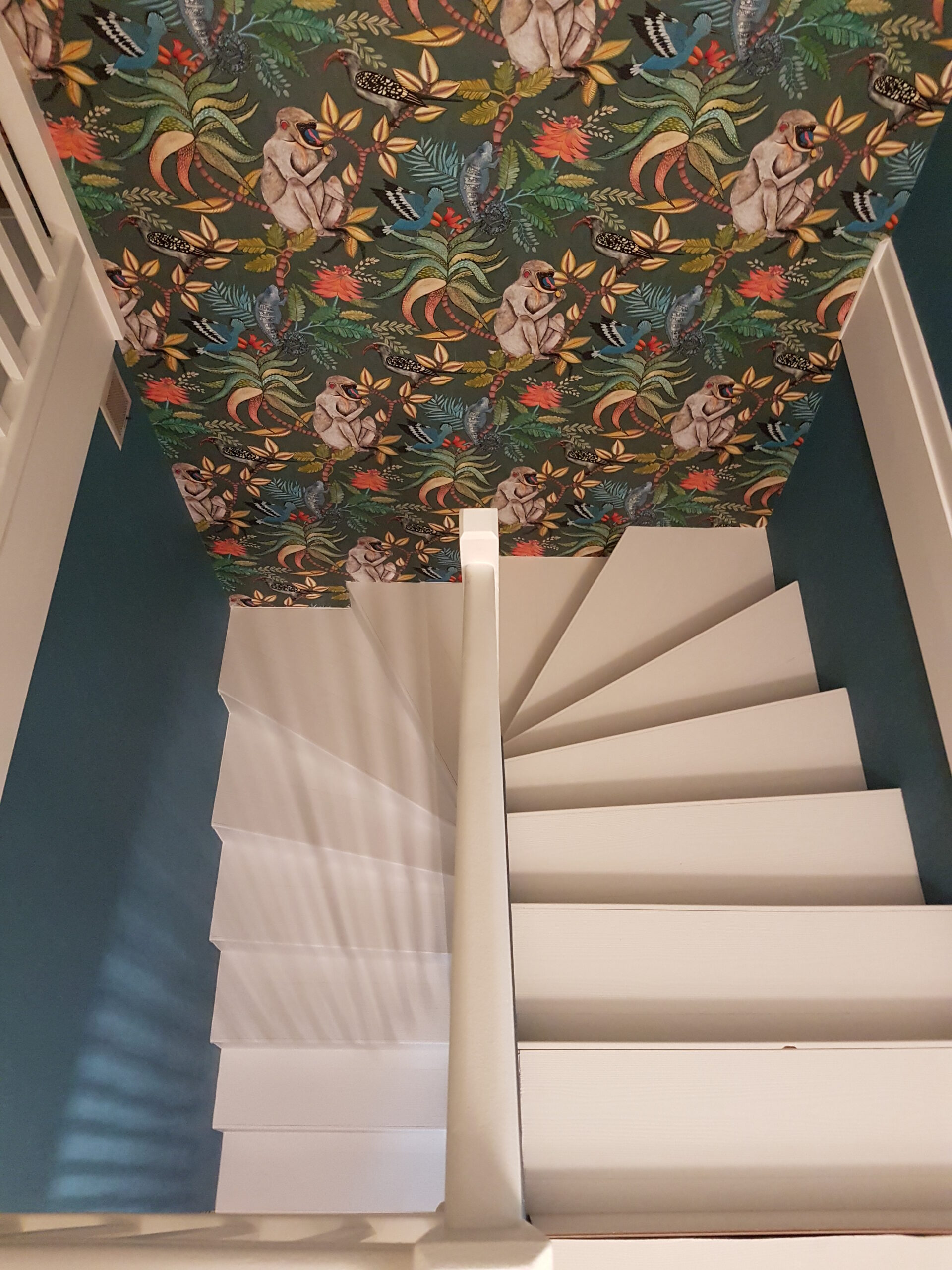 Escalier en bois rénové avec ponçage et pose de teinte blanche et vitrification.