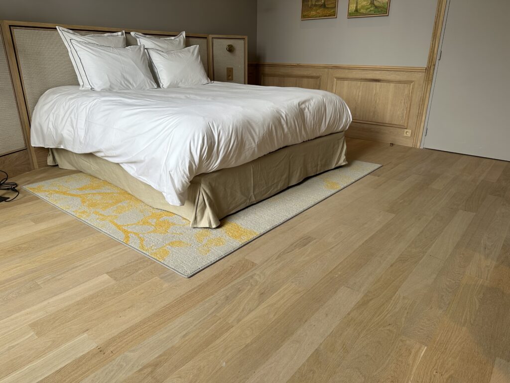 Photo de chambre d'hôtel montrant la réalisation d'une pose de parquets en chêne brut - pose à l'Anglaise