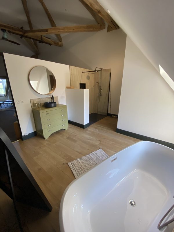 Photo d'une salle de bain d'hôtel montrant la réalisation d'une pose de parquets en pose traditionnelle à l'Anglaise - Chêne brut vernis mat