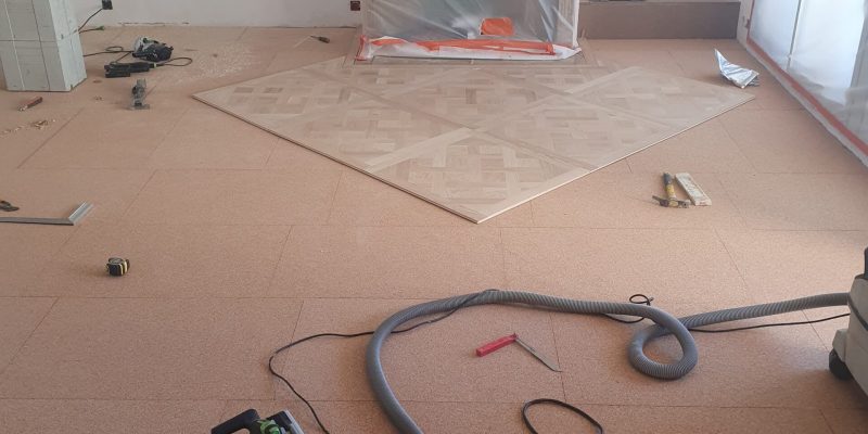 Photo d'un pose de Parquet Marqueté - étape pose collée des panneaux de Versailles