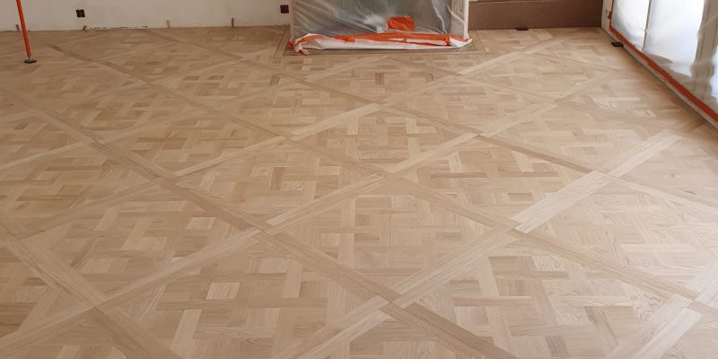 Photo d'un pose de Parquet Marqueté - étape fin de la pose des panneaux de Versailles en chêne brut