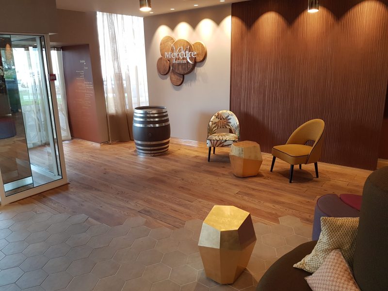 Photo montrant l'entrée d'un Hôtel. Réalisation d'incrustation de parquet avec du carrelage - Pose de parquets à L'Anglaise