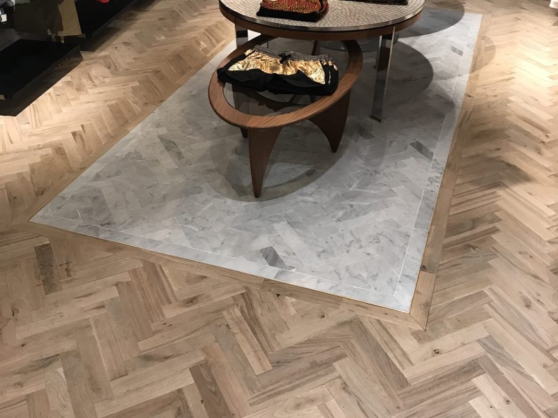 Photo d'intérieur de magasin montrant la réalisation d'un pose de parquet en chêne - pose en bâton Rompus - Brut vernis mat