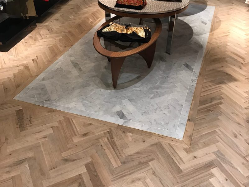 Photo d'intérieur de magasin montrant la réalisation d'un pose de parquet en chêne - pose en bâton Rompus - Brut vernis mat