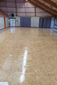 Finition de la salle polyvalente avec vitrification en 3 couches aspect satiné incolore.