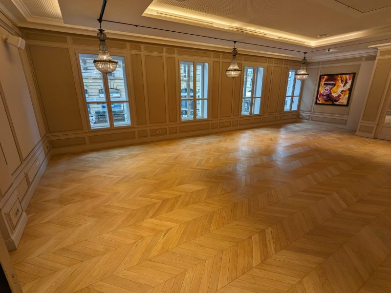 Photo d'une grande salle montrant la réalisation d'une pose en point de Hongrie - chêne massif - vernis satiné teinte miel