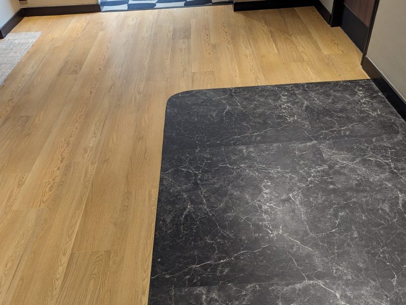 Photo d'un Hall montrant la réalisation d'un pose de parquets en incrustation avec du carrelage marbre - pose traditionnelle